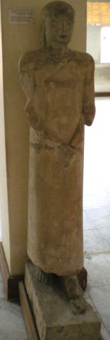 Statue en calcaire d'un fonctionnaire debout sur un piédestal. Abousir el Malaq. Période ptolémaïque.