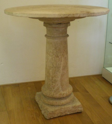 Table en pierre à plateau circulaire et pied mouluré.
