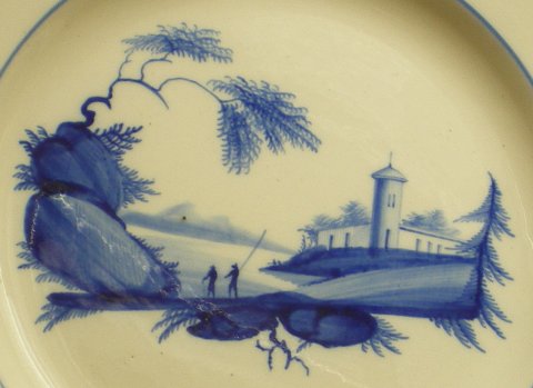 Assiette décorée d'un paysage de style chinois en camaïeu bleu.