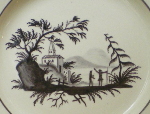 Assiette décorée d'un paysage de style chinois en camaïeu brun.