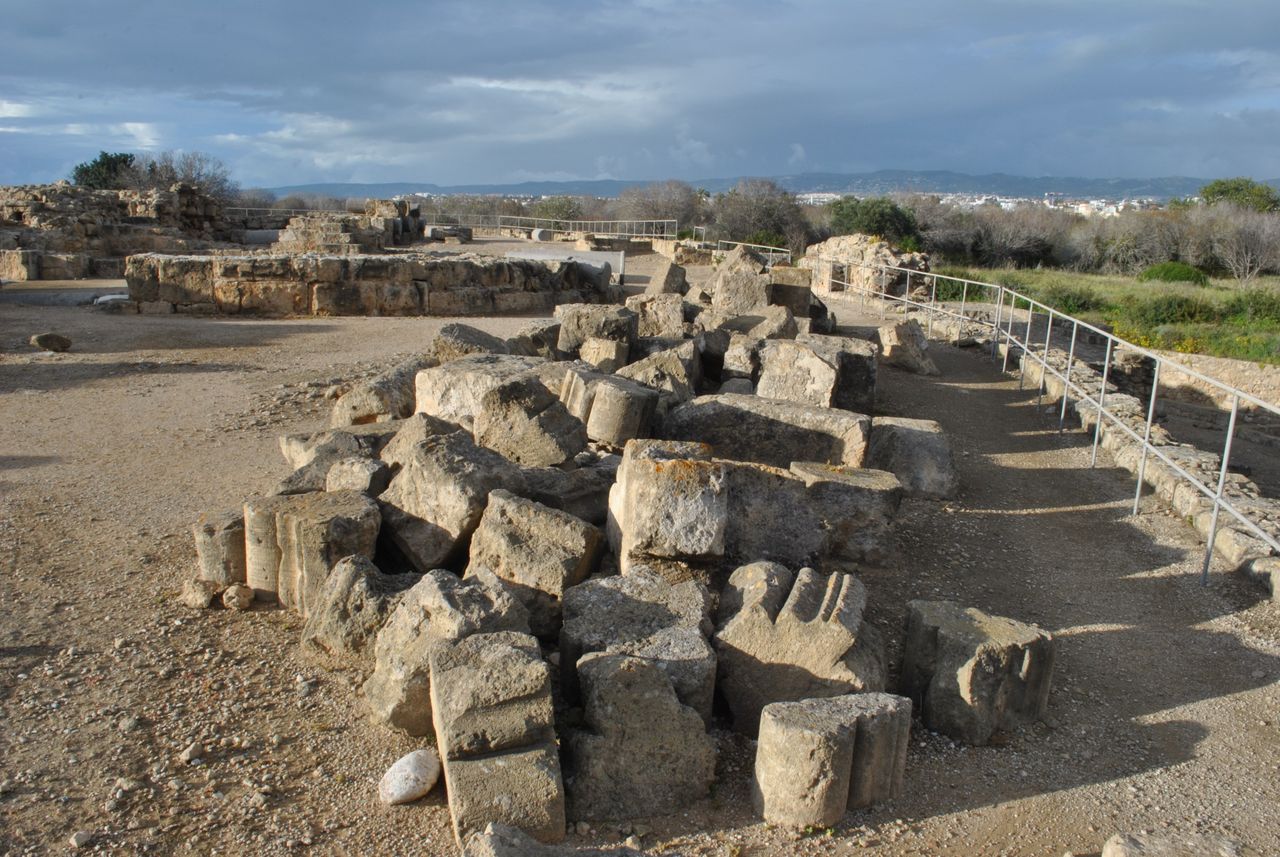 services-05 Scenic view of ancient ruins with fragmented stone columns and overcast skies.